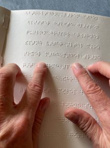 zwei Hände lesen Braille-Schrift