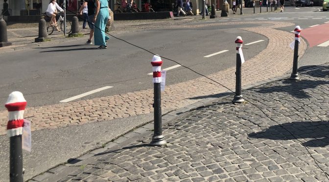 Straßenansicht Bonn Martinsplatz mit "bemützten" Pollern in rot-weiß